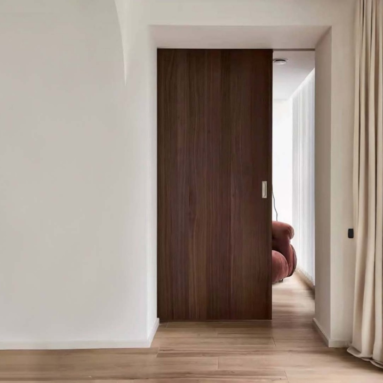 Wooden pocket door opening into a modern interior
